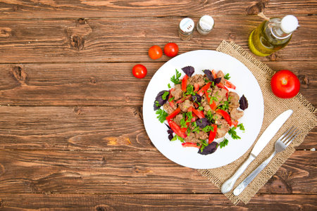 Fried liver with onion and tomatoes on wooden background.の写真素材