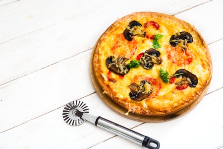 Fresh pizza in a rustic Italian style with mushrooms on a light wooden background.の写真素材
