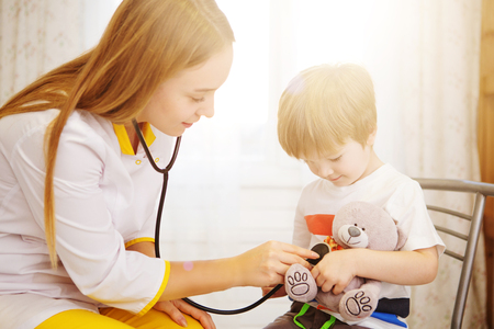 Pediatrician examining baby boy. Doctor using stethoscope to listen to kid and checking heart beat.の写真素材