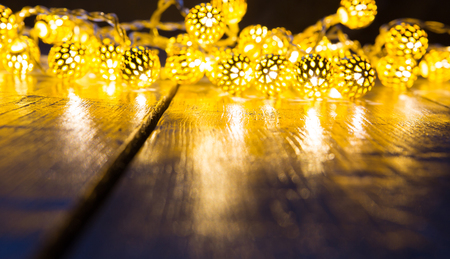 Yellow Christmas lights background with wooden floor.の写真素材