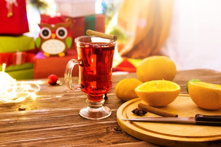 Traditional winter drink mulled wine in a glass on a wooden table.の写真素材