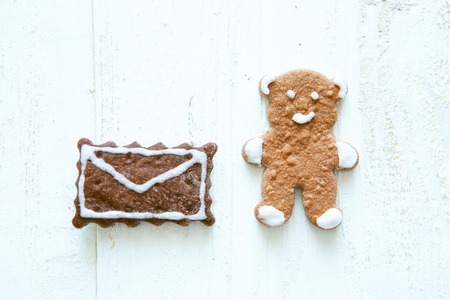 Homemade gingerbread bear and envelope cookie on a white wooden backgroundの写真素材