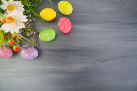 Colorful easter decoration with and flowers on a gray wooden table. Top viewの写真素材