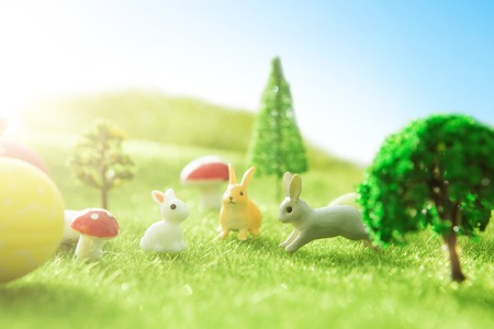 Colorful easter eggs and a big yellow easter egg on spring green grass.の写真素材