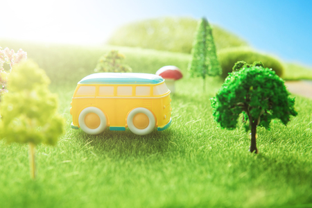 Yellow bus toy on a green grass.の写真素材