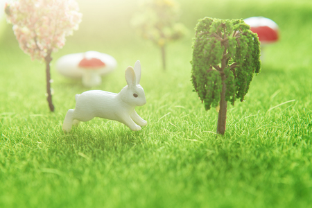 Rabbits near an easter eggs on a green grass field.の写真素材