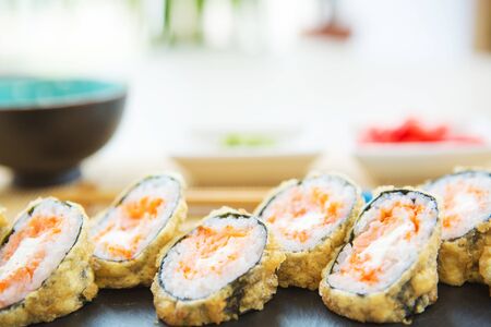 Unusual sushi rolls on a wooden table. Ukrainian sushi rolls with baked cheese and crabs Healthy and tasty food.の写真素材