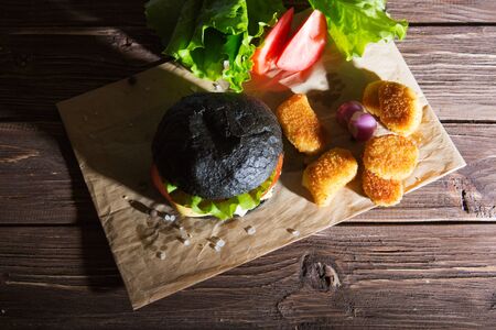 Delicious fast food. Fresh tasty burger on wood tableの写真素材