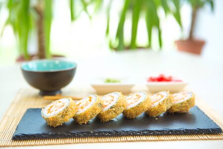 Set tamagoyaki sushi roll with rice, cheese, salmon and avocado closeup on a plate on the table. vertical Healthy and tasty food.の写真素材