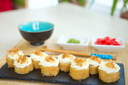 Japanese breakfast set tamagoyaki sushi roll with rice, cheese, salmon and avocado closeup on a plate on the table. vertical Healthy and tasty food.の写真素材