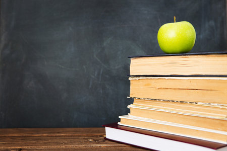 Green apple over pile of books for school concept. Education concept, toned and soft focus image