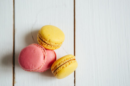 Sweet colorful French macaroon cookies dessert on white wooden tableの写真素材