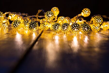 Christmas lights on a wooden table to be used as background or texture.の写真素材