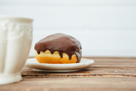 Sweet chocolate opera danish cake on wood plate with hot coffee isolated on tableの写真素材