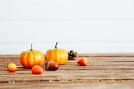 Pumpkins on a wooden table against white wooden wall Organic food and healthy food concept...