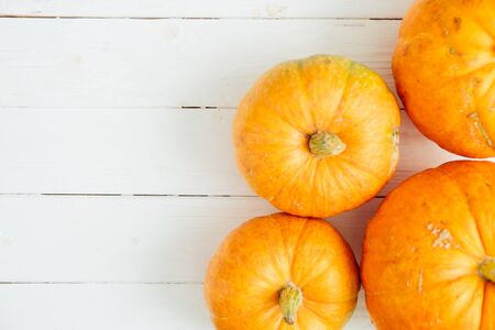 Pumpkins on white wooden background with copy space. Thanksgiving and Halloween concept. View from above. Top view. Copy space for text and designの写真素材