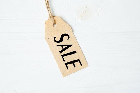 Label tag blank with word SALE on wooden One paper blank tags with word SALE with rope on wooden background.の写真素材