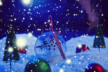 Christmas background with Christmas balls on snow over fir-tree, night sky and moon. Shallow depth...