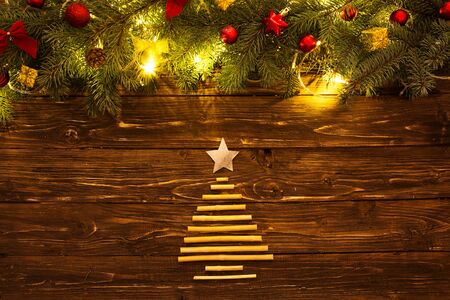 Christmas background with fir tree and decoration with Christmas tree for dry sticks on dark wooden board.の写真素材