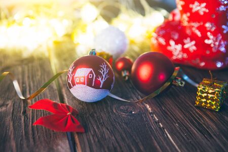 Christmas decorations on a brown wooden table with christmas lights.の写真素材