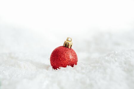 red christmas ball lying on snow Beautiful Christmas bauble decorations lie on the white fluffy snow. Atmosphere of magic and fairy talesの写真素材