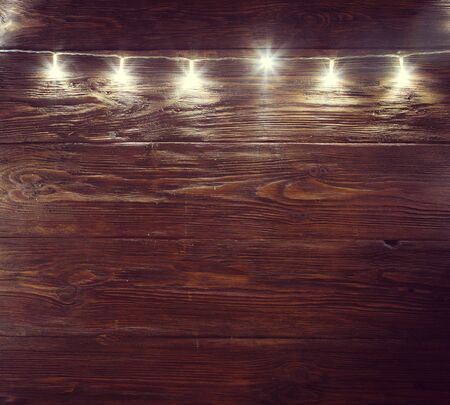 Christmas lights decorations on a rustic wooden table. Christmas or New Year concept. Blur christmas lights on wooden planks.の写真素材