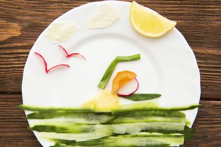 Vegetables, organic produce on wooden table. Healthy lifestyle concept - vegetable swimmer athlete on dish on wooden. Healthy eating.の写真素材