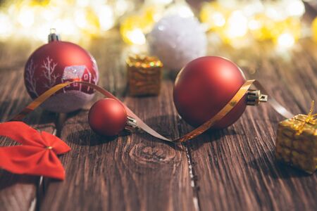 Christmas decorations on a brown wooden table with Christmas lights.の写真素材