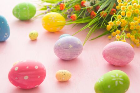 Easter eggs with wild flowers on a wooden pink table backgroundの写真素材