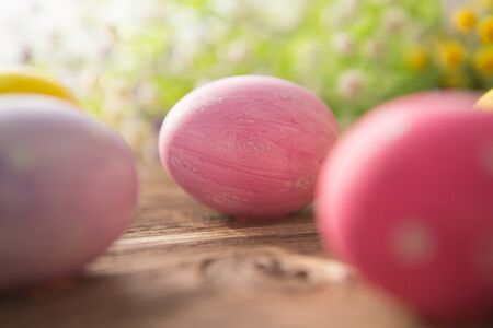 Colorful easter eggs with flowers on a old wooden surfaceの写真素材
