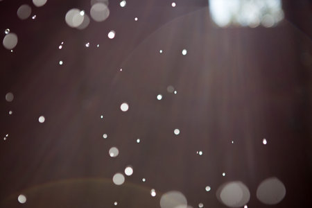 Abstract background with highlights and bokeh from splashing water, light from lanterns and the sun