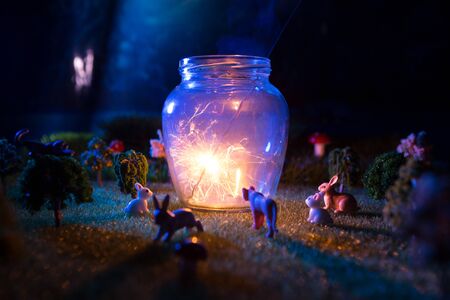 Fairy forest. The animals gathered to see a miracle lamp shining from sparklers. Fictional fairytale macro worldの写真素材