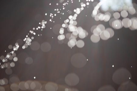 Abstract background with highlights and bokeh from splashing water, light from lanterns and the sun