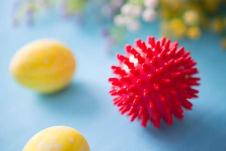 Virus model of Coronavirus disease COVID-19 with colorful easter eggs with flowers on a blue wooden...
