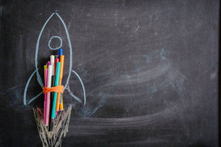 Chalk drawing of a rocket on the background of blackboard. Back to school