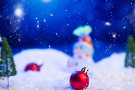 Christmas background with Christmas balls on snow over fir-tree, night sky and moon. Shallow depth...