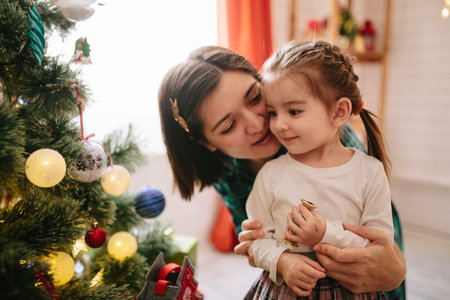 Happy family mom and daughter on a Christmas winter sunny morning in a decorated Christmas...