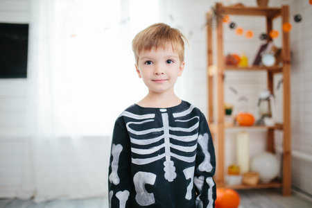 Holiday halloween. Funny little boy in a skeleton costume is ready to celebrate Halloween. Boy in a...