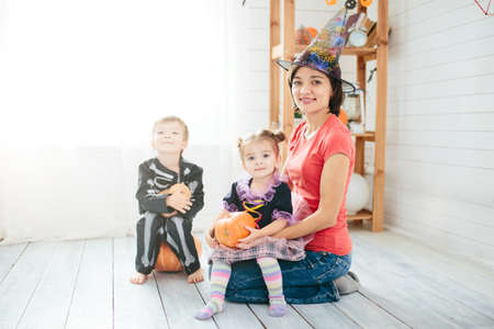 Happy family of mother and children prepare for Halloween in decorate the homeの写真素材
