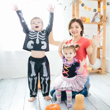 Happy family of mother and children prepare for Halloween in decorate the homeの写真素材