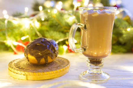 Woman hands ith cup of hot chocolate on christnas tree background