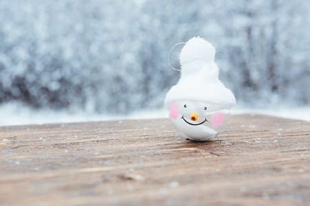 Beautiful Christmas bauble decorations lie on the wooden table over snow covered forest background. ...の写真素材