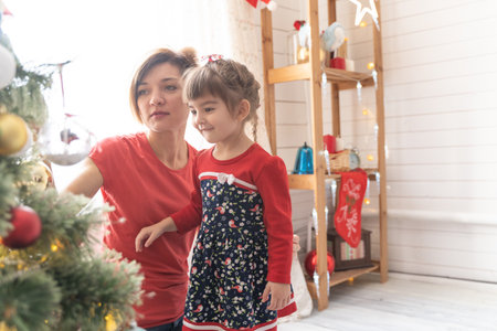 Mom and daughter decorate the Christmas treeの写真素材