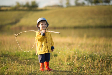 Child boy ready for fishing. Cute little boy in hat holding big fishing net at the ready.の写真素材