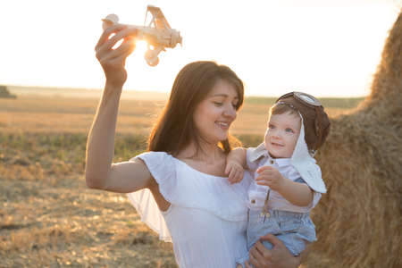 Mother hugging her child during walk in the park over sunsetの写真素材