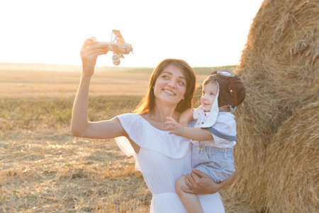 Mother hugging her child during walk in the park over sunsetの写真素材