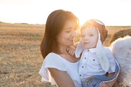 Mother hugging her child during walk in the park over sunsetの写真素材