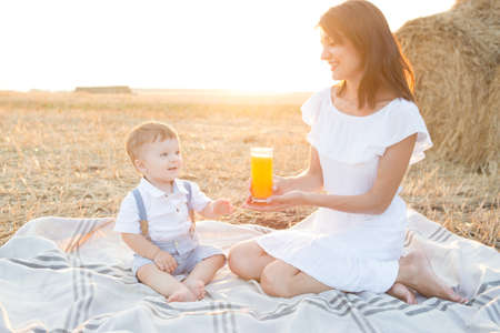 Mother hugging her child during walk in the park over sunsetの写真素材