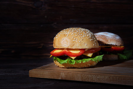 Hamburger on wood board over rustic backgroundの写真素材