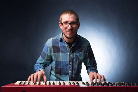 Artist playing on the keyboard synthesizer piano keys. Male musician plays a musical instrumentの写真素材